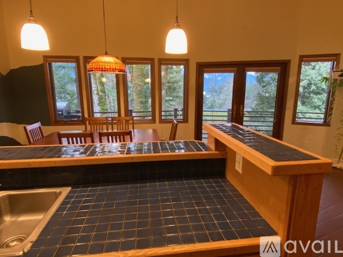A kitchen with a table and chairs and a sink.