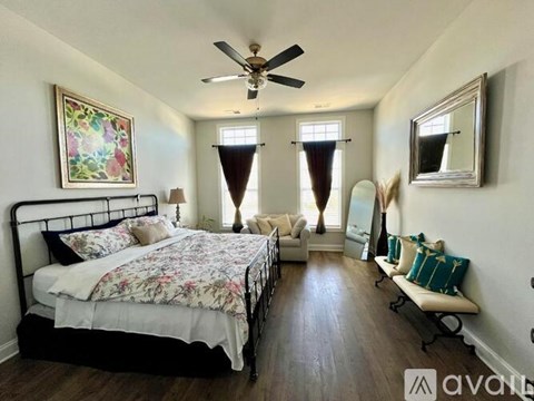 A bedroom with a large bed and a bench.