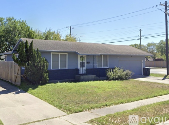 A house with a blue front and a grey roof.