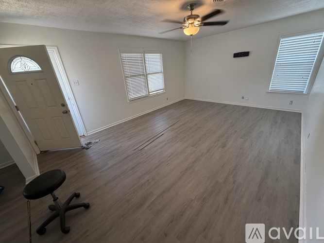 A room with a ceiling fan and a chair.
