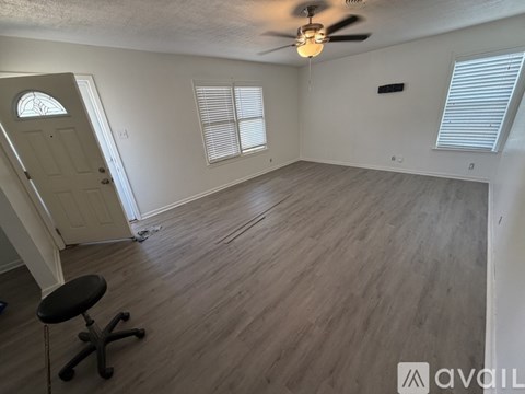 A room with a ceiling fan and a chair.