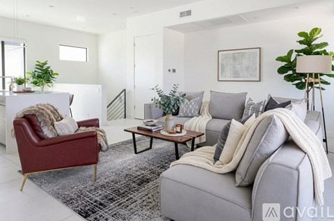 A living room with a red chair and a grey sofa.