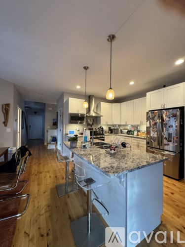 A kitchen with a granite countertop and stainless steel appliances.