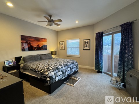 A bedroom with a large bed and a ceiling fan.