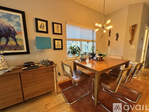 A dining room with a wooden table and chairs.