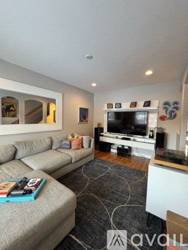 A living room with a grey couch and a television.