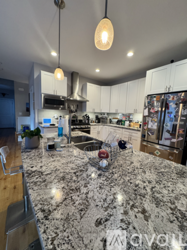 A kitchen with a marble countertop and a refrigerator covered in magnets.