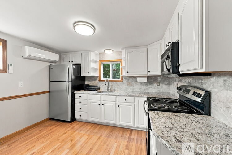 A kitchen with white cabinets and a granite countertop.