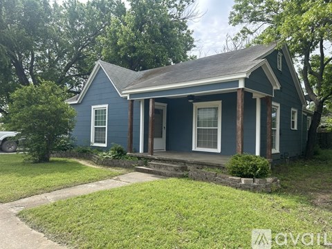 A blue house with a porch and a white door.