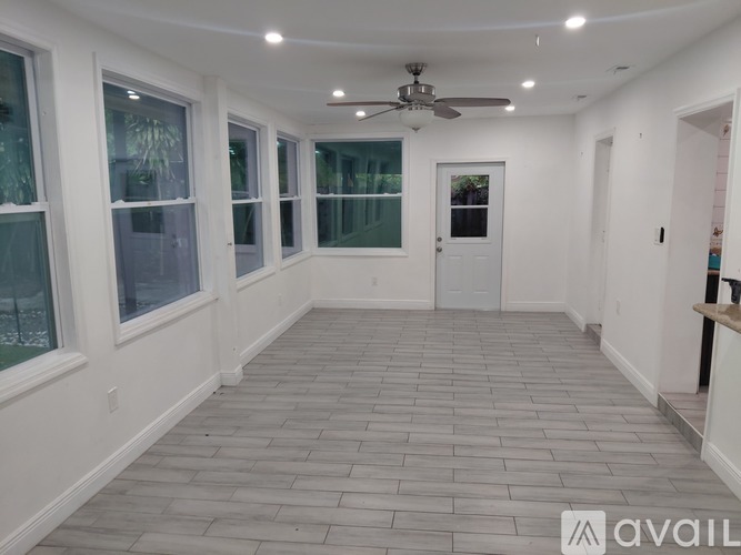 A spacious room with a ceiling fan and tiled flooring.