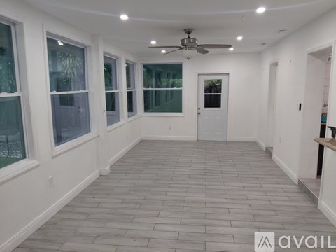 A spacious room with a ceiling fan and tiled flooring.