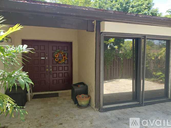 A house with a red door and a wreath on it.