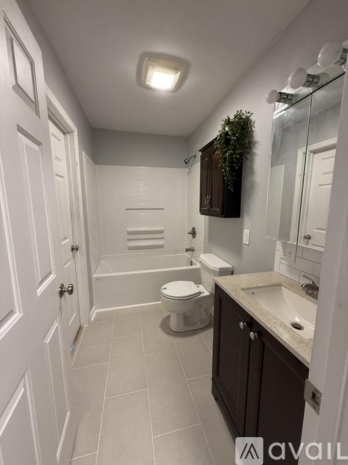 A bathroom with a toilet, sink, and a mirror.
