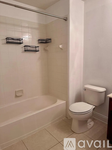 A white toilet sits next to a bathtub in a bathroom.