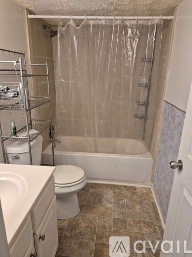 A bathroom with a toilet, sink, and shower.