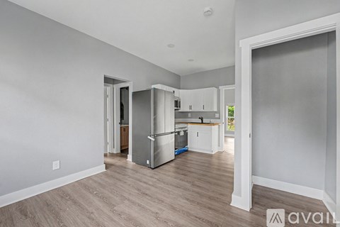 A kitchen area with a refrigerator, cabinets, and a countertop.