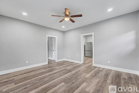 A room with a ceiling fan and two doors.