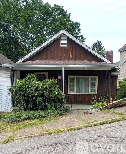 A small brown house with a white door and windows.