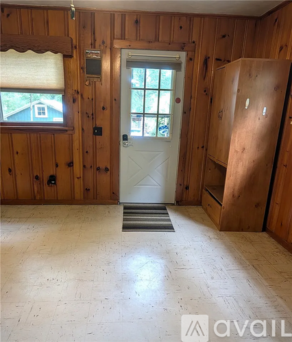 A room with wooden walls and a white door.