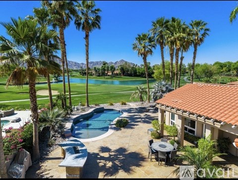 A house with a pool and palm trees in the background.