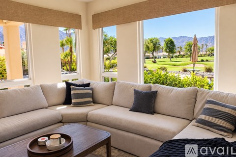 A living room with a large couch and a view of the mountains.
