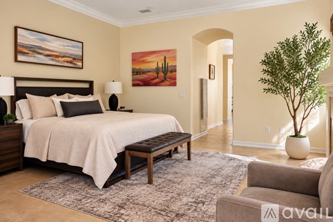 A bedroom with a large bed and a painting on the wall.