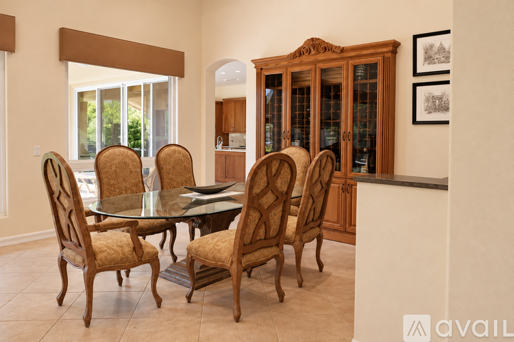 A dining room with a glass table and chairs.