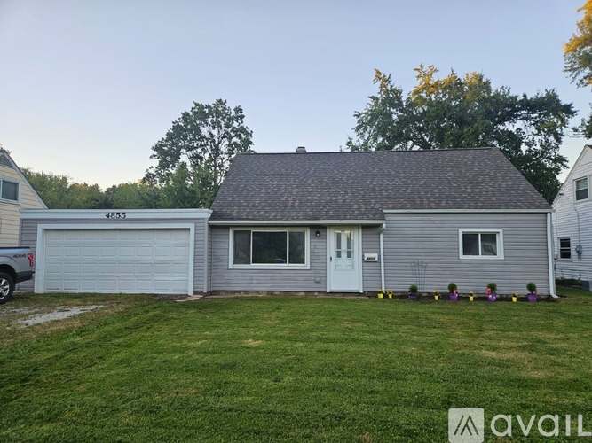 A house with a garage and a driveway in front of it.