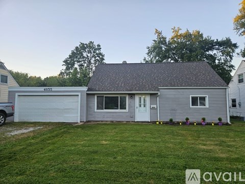A house with a garage and a driveway in front of it.