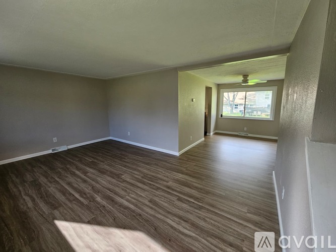 A room with wooden flooring and a window.