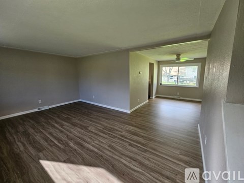 A room with wooden flooring and a window.