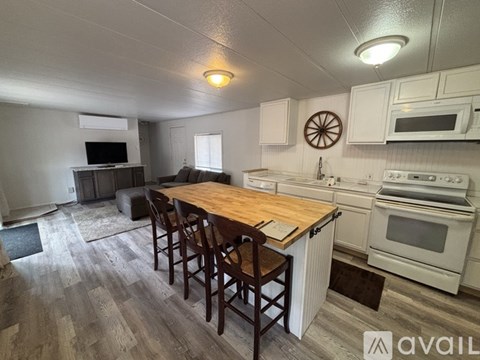 A kitchen with white cabinets and a wooden island.