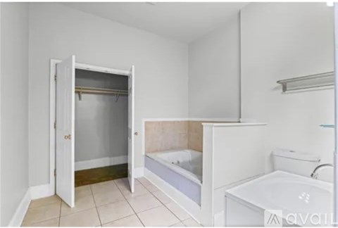 A white bathroom with a bathtub, toilet, and a walk-in shower.
