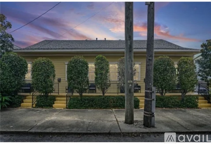A house with a front yard and a telephone pole in front of it.