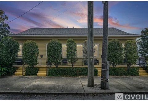A house with a front yard and a telephone pole in front of it.