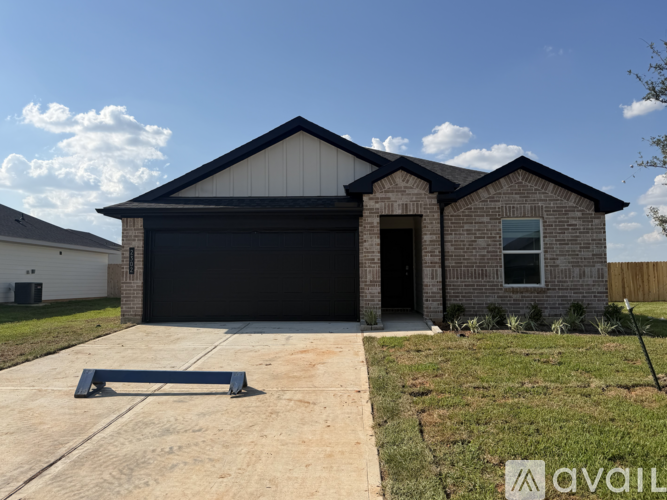 A house with a black garage door and a brick exterior.