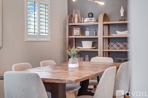 A dining room with a wooden table and chairs.