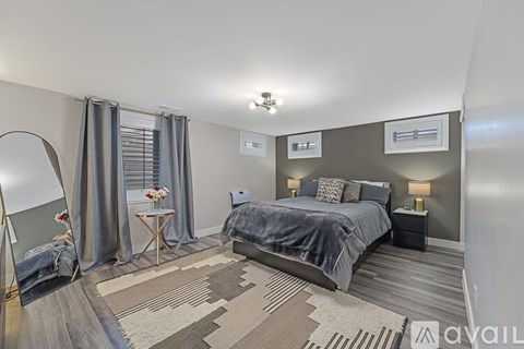 A bedroom with a large bed and a rug on the floor.