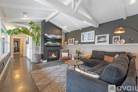 A modern living room with a grey sofa and a fireplace.