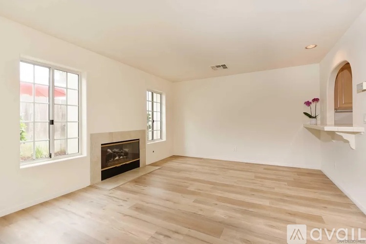 A spacious living room with a fireplace and wooden flooring.