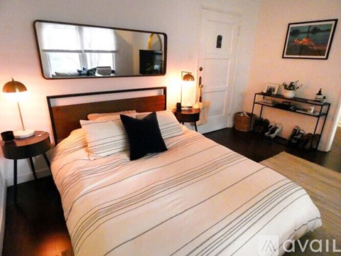 A bedroom with a large bed and a mirror above it.