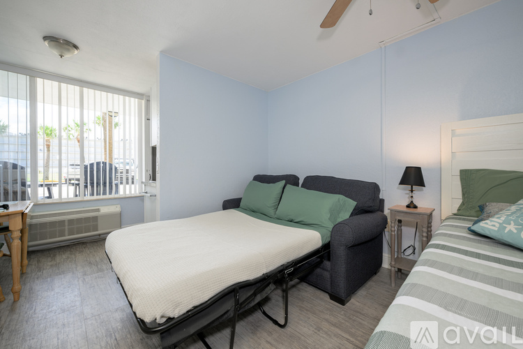 A bedroom with a bed, a chair, and a nightstand.