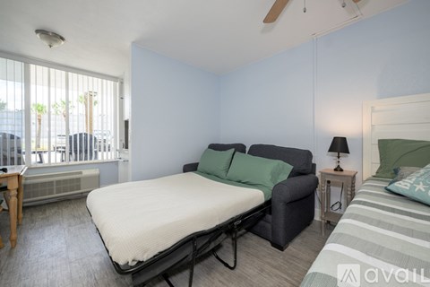 A bedroom with a bed, a chair, and a nightstand.