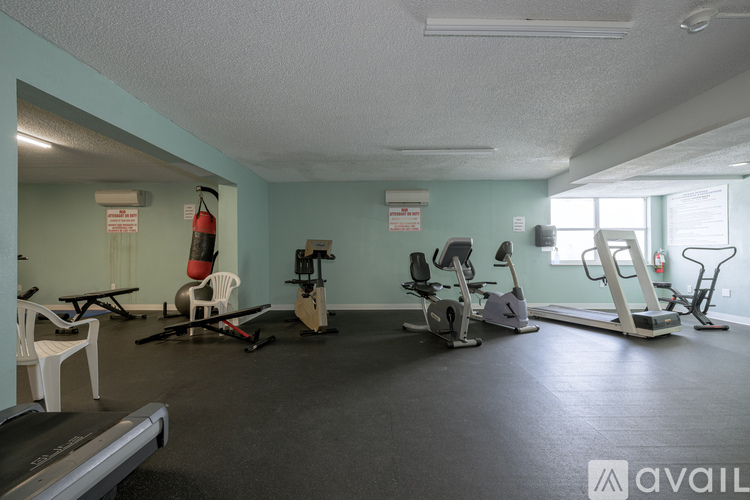A gym with a treadmill, exercise bike, and other equipment.
