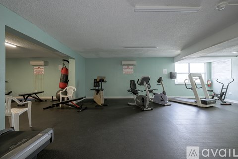 A gym with a treadmill, exercise bike, and other equipment.