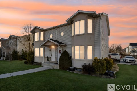 A house with a front yard and a car parked in the driveway.