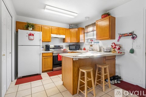 A kitchen with wooden cabinets and a white refrigerator.