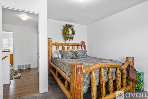 A bedroom with a bed and a wreath on the wall.
