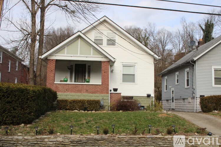 A house with a red brick chimney and a white siding.