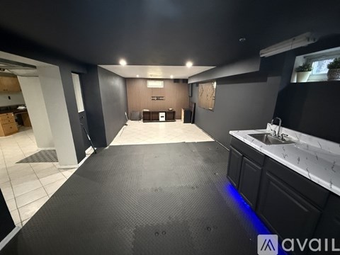 A spacious room with a black floor and a white counter on the right side.